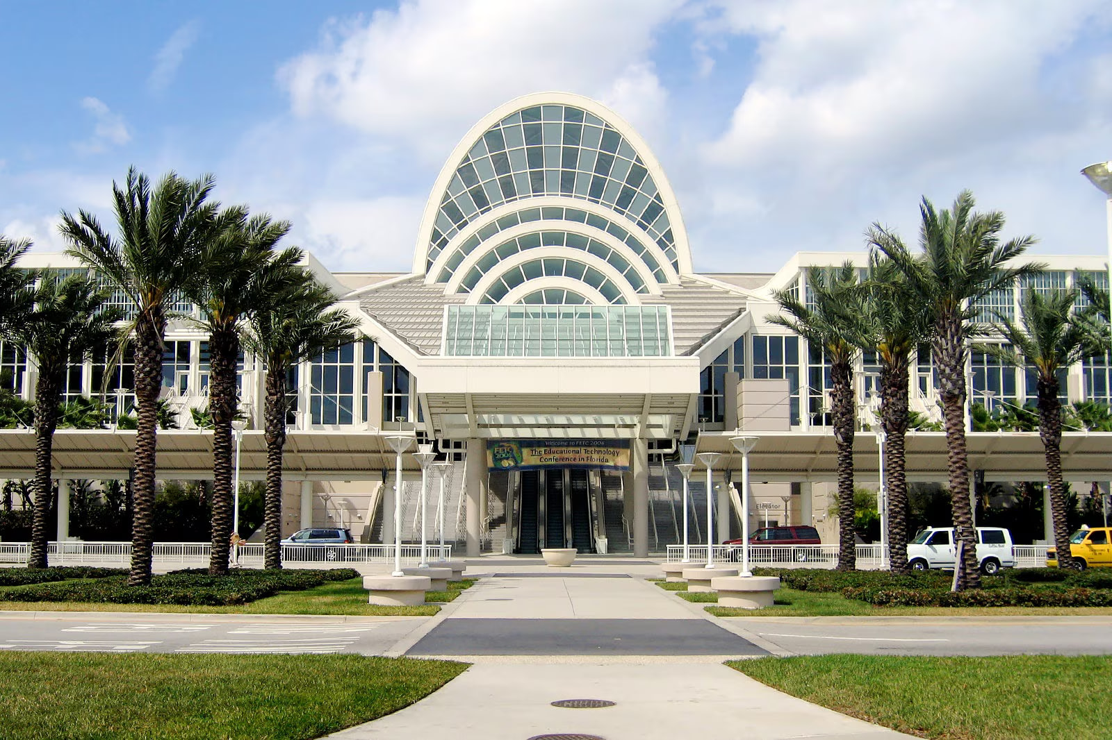 Orange County Convention Center Exterior – Iconic Arched Glass Façade Framed By Palm Trees And Blue Florida Sky