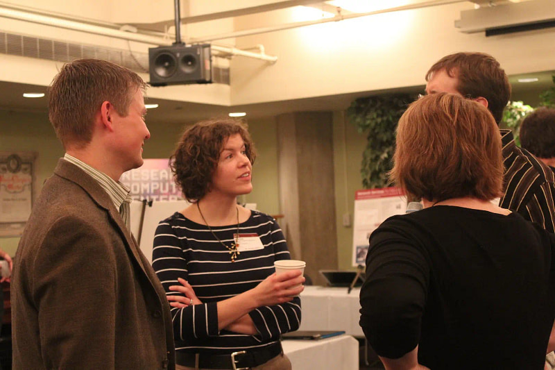 Four professionals speaking together at an event.