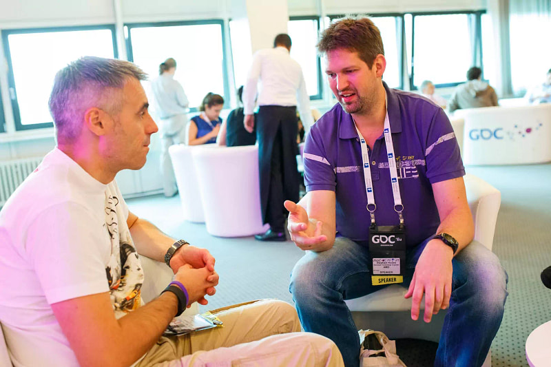 Exhibition management project manager advising exhibitor in trade show lounge